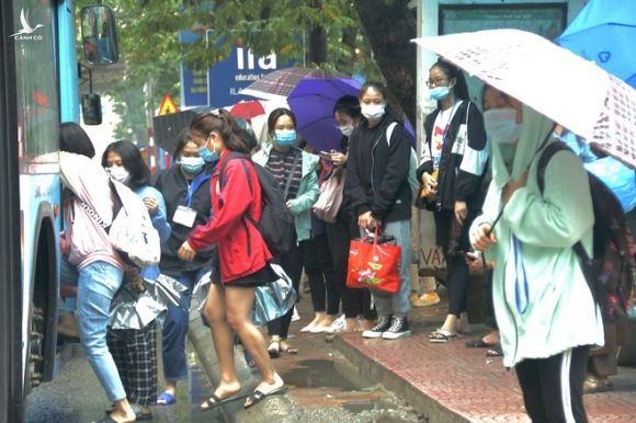 Một số sinh viên đón xe buýt thực hiện nghiêm túc việc đeo khẩu trang /// Ảnh: Dương Lan