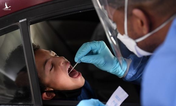 Nhân viên y tế lấy mẫu xét nghiệm Covid-19 cho một cậu bé ở bang Nevada, Mỹ hôm 12/11. Ảnh: AFP.
