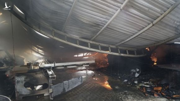 Mái tôn của một xưởng gỗ đổ sập trong đám cháy. Ảnh: Phạm Tuấn