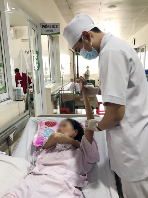 Kỹ thuật viên phục hồi chức năng đang tập vận động cho bệnh nhân. Ảnh: Lê Hồng Tuấn.