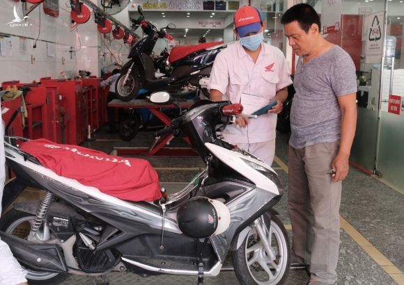 Ông Nguyễn Thành Công, 58 tuổi, đi kiểm tra khí thải xe máy tại một đại lý ở quận 3, hồi tháng 6. Ảnh: Gia Minh.