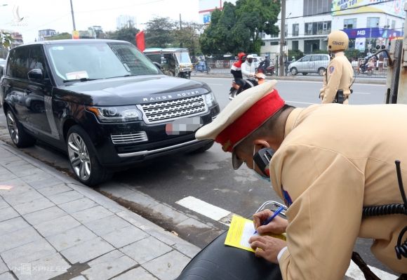 Cảnh sát ghi thông báo phạt nguội với xe ôtô vi phạm trên đường Giải Phóng, Hoàng Mai vào sáng 15/12. Ảnh: Phương Sơn