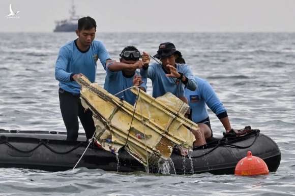 Thợ lặn hải quân Indonesia vớt một mảnh vỡ máy bay gần đảo Lancang sáng 10/1. Ảnh: AFP.