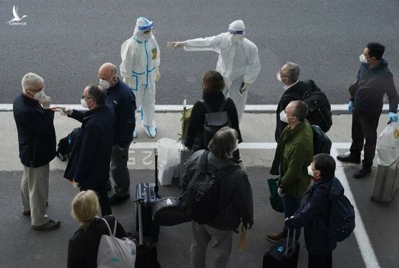 Phái đoàn chuyên gia WHO được nhân viên Trung Quốc hộ tống tại sân bay Vũ Hán, ngày 14/1. Ảnh: Associated Press