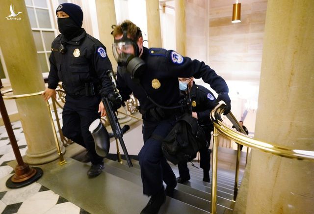 Một cảnh sát đeo mặt nạ phòng độc bên trong trụ sở quốc hội (Ảnh: Reuters)
