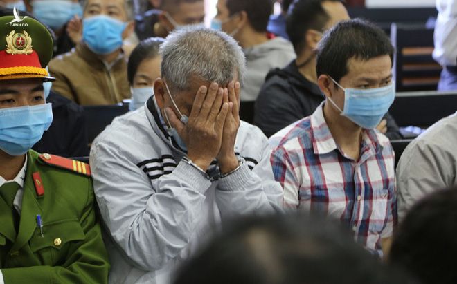 Đại gia xăng dầu Trịnh Sướng lấy tay che mặt trước ống kính của phóng viên tại tòa