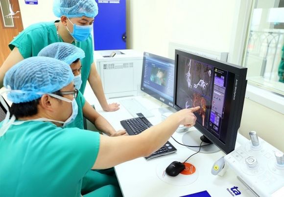 Bác sĩ phẫu thuật trao đổi về mô hình 3 chiều kỹ thuật số trên máy tính ngay tại khu điều khiển trong phòng mổ hybrid hiện đại. Ảnh: Bệnh viện Đa khoa Tâm Anh.