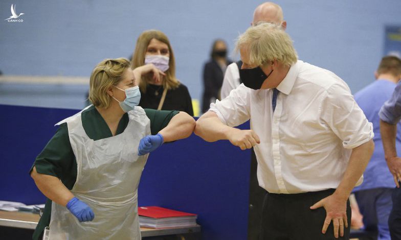 Thủ tướng Anh Boris Johnson (phải) đến thăm một trung tâm tiêm chủng ở Cwmbran, miền nam xứ Wales hôm 17/2. Ảnh: AFP.
