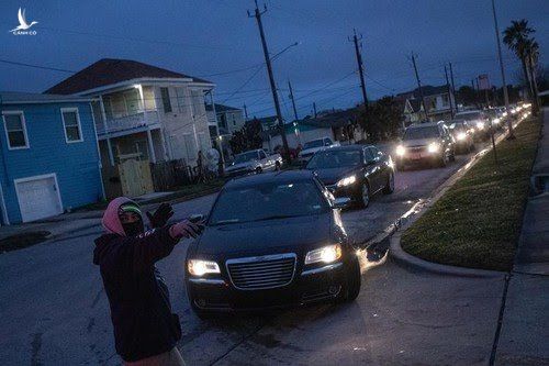 Người dân xếp hàng vào một trung tâm sơ tán ở Galveston (bang Texas). Hàng triệu người phải đối mặt với lựa chọn ở trong căn nhà lạnh lẽo hoặc có nguy cơ lây chéo COVID-19 trong các khu sơ tán. Ảnh: Reuters