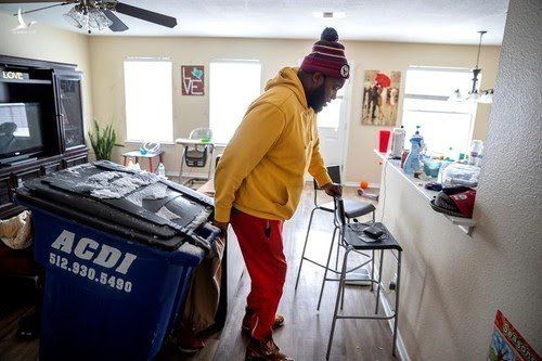Một người dân ở Hutto (bang Texas) kéo thùng rác vào nhà để loại bỏ thức ăn hỏng vì không bật được tủ lạnh. Ảnh: Reuters