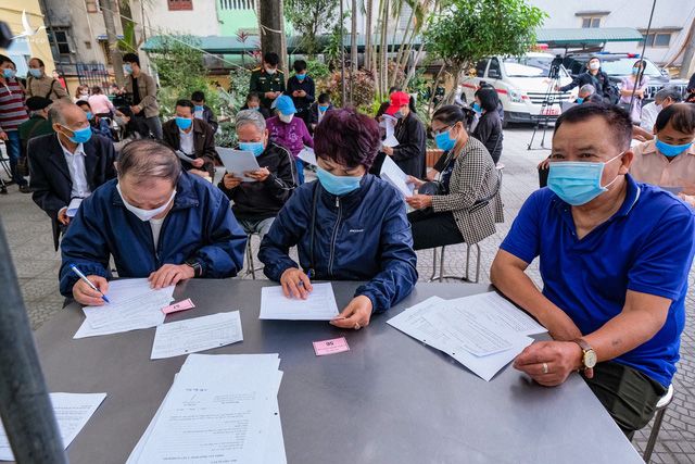 Tình nguyện viên khai báo y tế và đăng ký trước khi được khám sàng lọc trước tiêm - Ảnh: NAM TRẦN