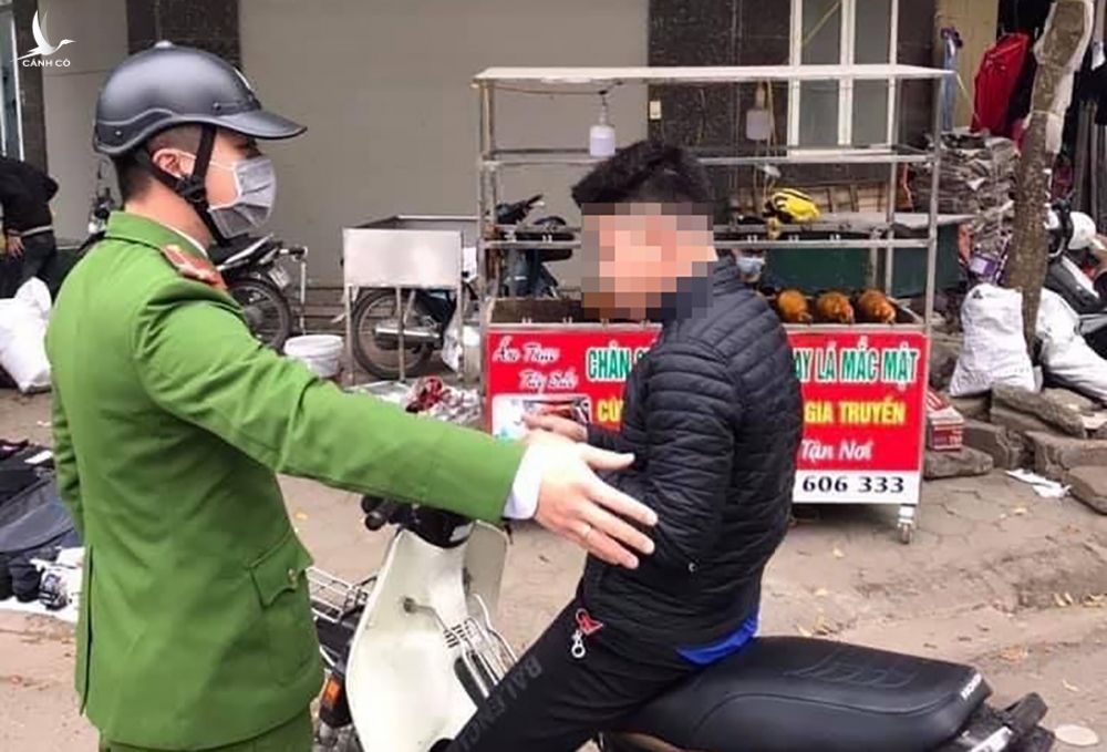 Cảnh sát ra quân xử phạt người không đeo khẩu trang. Ảnh: Phạm Dũng.
