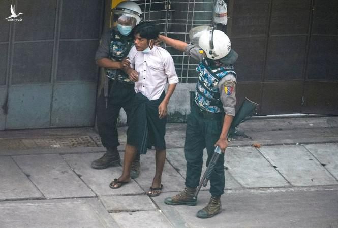 Cảnh sát Myanmar khống chế một người biểu tình ngày 19/3. Ảnh: Reuters