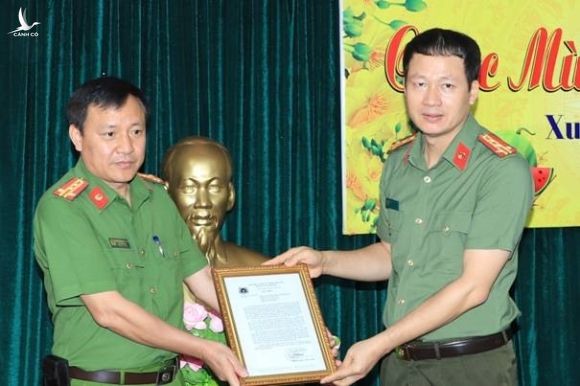 Đại tá Vũ Hồng Văn (phải) nhận thư khen của lãnh đạo Bộ Công an sau chuyên án phá đường dây 200 triệu lít xăng giả. Ảnh CAĐN