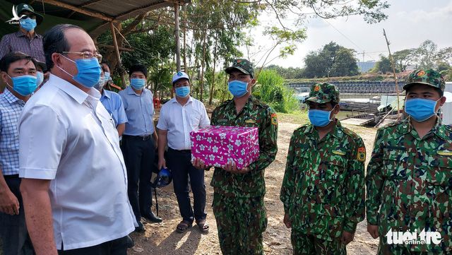 Chủ tịch UBND tỉnh An Giang Nguyễn Thanh Bình (bìa trái) tặng quà cho các cán bộ, chiến sĩ chốt phòng chống dịch COVID-19 ven sông Bình Di - Ảnh: BỬU ĐẤU