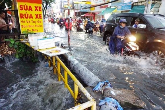 Nước chảy cuồn cuộn xuống con suối gần đường ray cắt ngang đường Tô Ngọc Vân (Thành phố Thủ Đức). Ảnh: Minh Quân