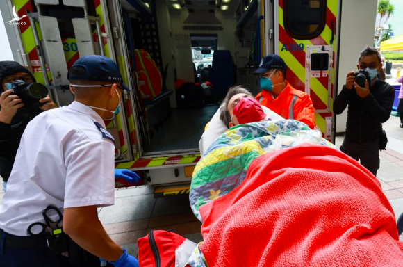 Một người đàn ông được đưa vào xe cấp cứu do gặp phản ứng phụ sau tiêm vaccine Covid-19 của Pfizer. Ảnh: SCMP