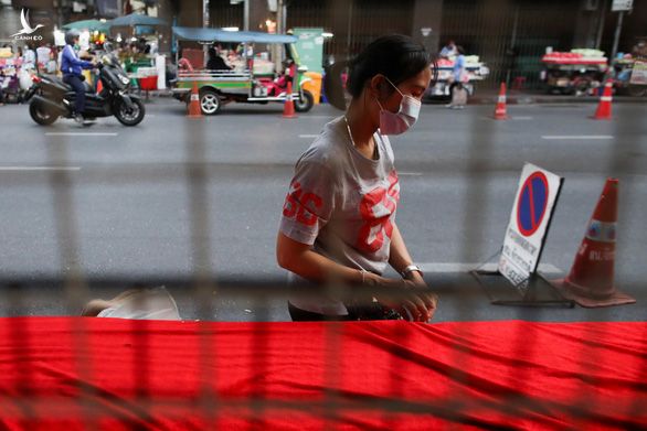 Một phụ nữ đeo khẩu trang khi đi lại trên đường phố Bangkok ngày 23-4 trong bối cảnh Thái Lan đang bùng phát làn sóng dịch bệnh COVID-19 mới.