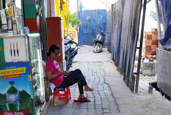 Bà Kiều ngồi trước cửa hàng, trước mặt là rào chắn chông trình Metro Số 1, chiều 7/4. Ảnh: Gia Minh.