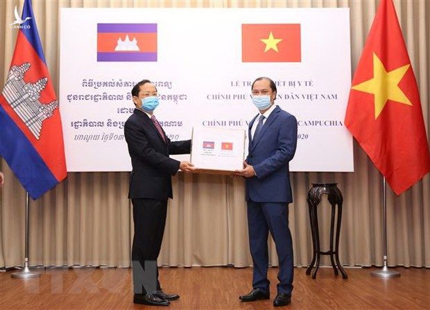 Thứ trưởng Bộ Ngoại giao Nguyễn Quốc Dũng (bên phải) trao tặng biểu trưng thiết bị y tế cho Đại sứ Campuchia tại Việt Nam Chay Navuth.