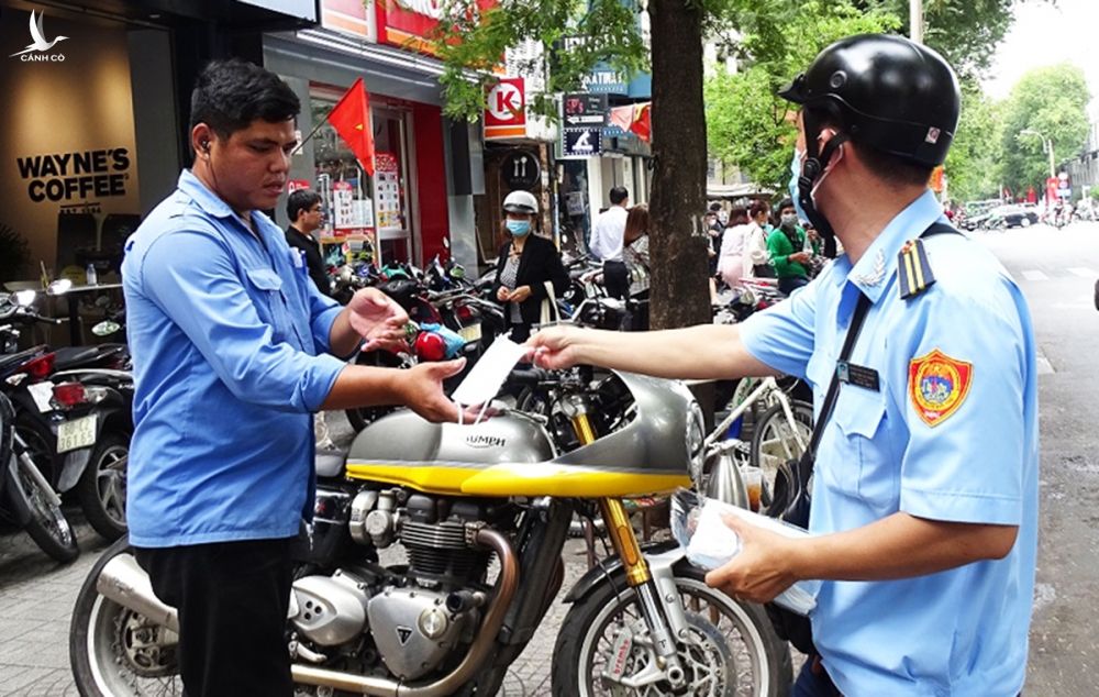 Người dân ở đường Nguyễn Du, phường Bến Nghé, được phát miễn phí khẩu trang. Ảnh: Hà An.