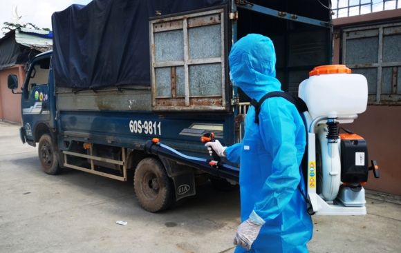 Nhân viên y tế khử khuẩn xe tải từ ngoại tỉnh vào Bà Rịa - Vũng Tàu trên quốc lộ 51, sáng 29/5. Ảnh: Trường Hà.