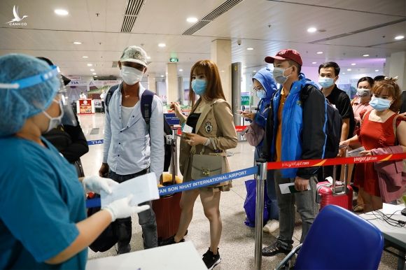 Nhân viên y tế đọc tên các hành khách chuẩn bị vào lấy mẫu xét nghiệm Covid-19 tại sân bay Tân Sơn Nhất đầu tháng 5. Ảnh: Hữu Khoa.