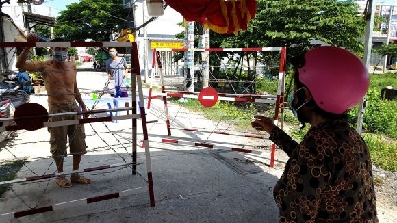 Bà Nguyễn Thị Anh (67 tuổi) mang đồ đến nhà người anh để cúng giỗ mẹ nhưng không thể vào trong /// ẢNH: TRẦN KHA
