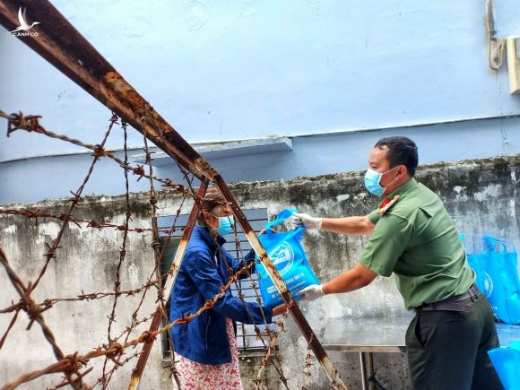 Một người dân sống trong khu phong tỏa tại P.Thạnh Lộc, Q.12 (TP.HCM) nhận quà tiếp tế từ các nhà hảo tâm /// Ảnh: Phạm Thu Ngân
