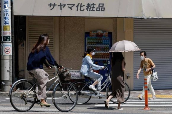 Người Nhật Bản đạp xe tại quận Shinagawa, Tokyo, ngày 19/7. Ảnh: AFP