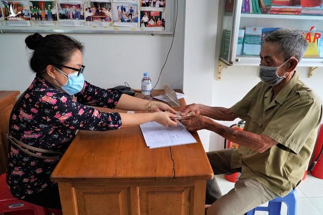 Cán bộ phòng LĐ-TB&XH trao tiền hỗ trợ tới ông Trần Văn Chợ, khu vực 4, phường An Bình, Ninh Kiều, Cần Thơ.