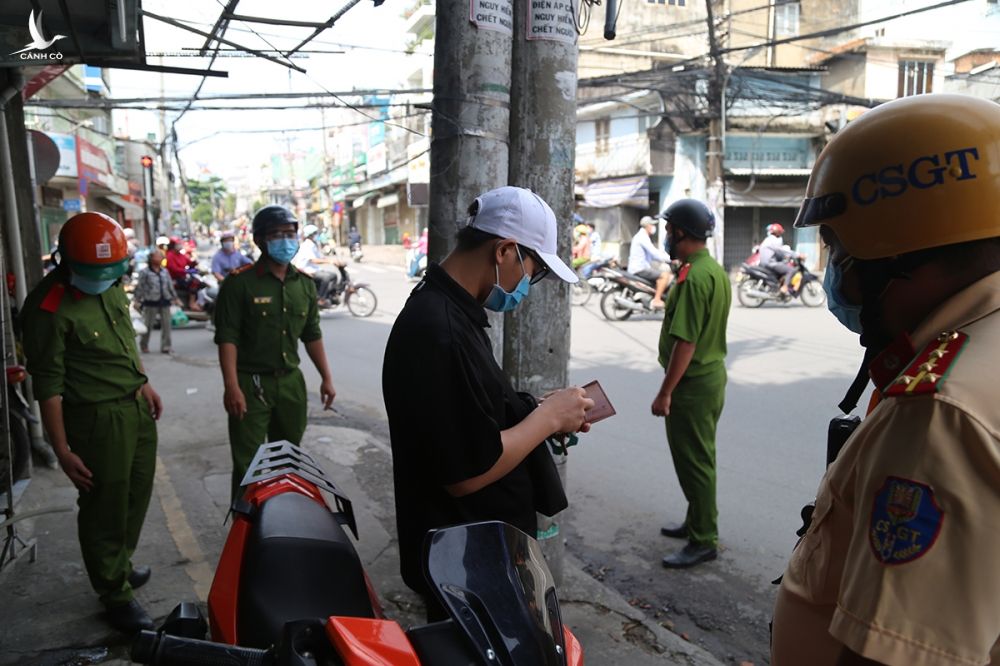 Cảnh sát kiểm tra người vi phạm phòng dịch ở quận Gò Vấp, sáng 14/7. Ảnh: Đình Văn.