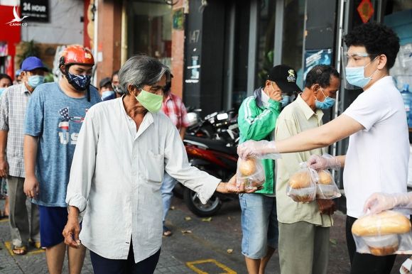 Người dân nhận đồ ăn miễn phí tại một điểm phát ở quận 1, ngày 18/6. Ảnh: Quỳnh Trần.