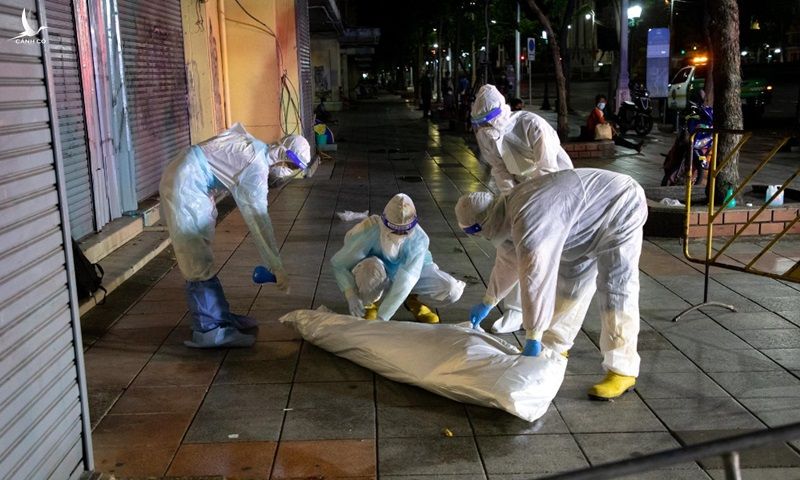 Nhân viên y tế thu hồi thi thẻ nạn nhân chết vì Covid-19 trên đường phố Bangkok, Thái Lan hôm 20/7. Ảnh: BenarNews.