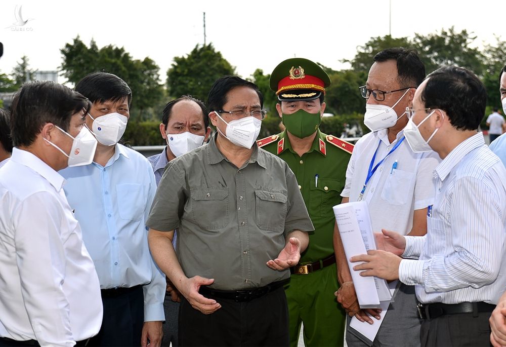 Thủ tướng nghe lực lượng chức năng báo cáo việc thực hiện Chỉ thị tại phường Tân Phú, TP Thủ Đức chiều 11/7. Ảnh: VGP