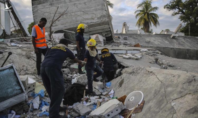 Lính cứu hỏa tìm kiếm người còn sống sót bên trong tòa nhà bị tàn phá ở Les Cayes, Haiti, hôm 15/8. Ảnh: AP.