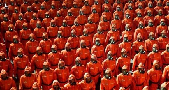 Đơn vị phòng chống dịch bệnh với bộ đồ bảo hộ màu cam và mặt nạ phòng độc trong lễ duyệt binh. (Nguồn: KCNA) 