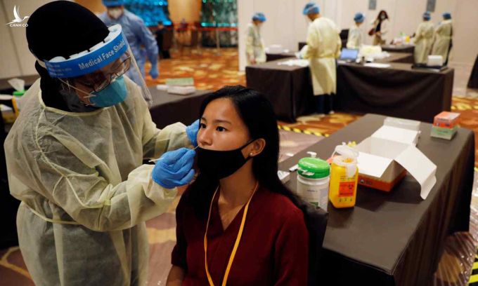 Nhân viên y tế lấy mẫu xét nghiệm Covid-19 cho người tham dự hội nghị tại Singapore hồi tháng 1. Ảnh: Reuters.