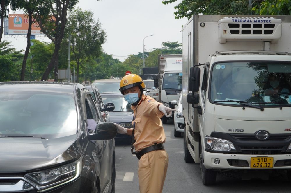 Cảnh sát giao thông kiểm tra giấy tờ tờ tài xế trên đường Đinh Bộ Lĩnh, quận Bình Thạnh, khi TP HCM áp dụng giãn cách xã hội theo Chỉ thị 16, tháng 8/2021. Ảnh: Gia Minh