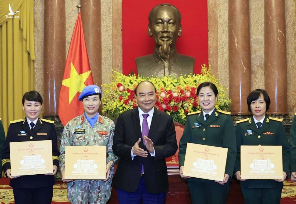 Chủ tịch nước Nguyễn Xuân Phúc tặng quà cho các đại biểu phụ nữ quân đội tại buổi gặp mặt.