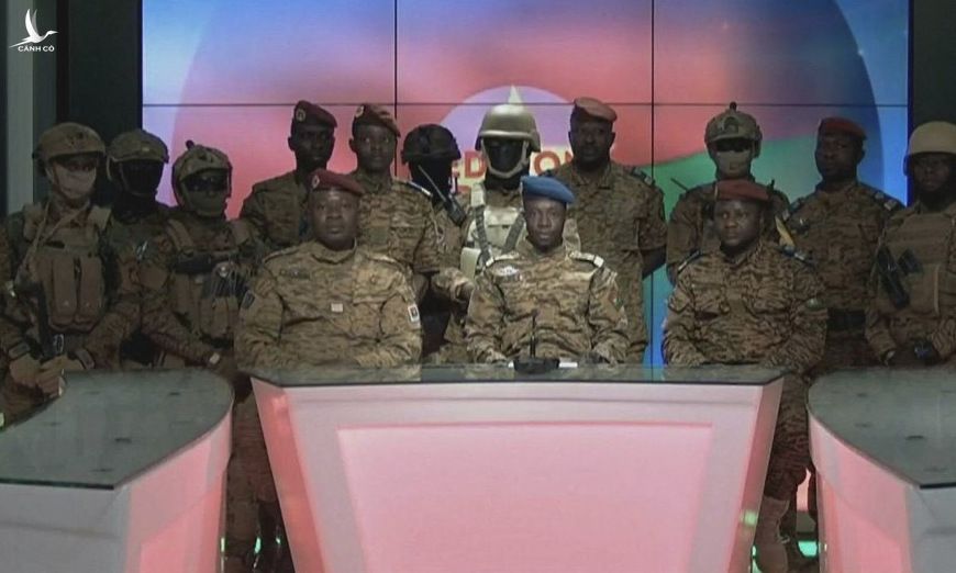 Trung tá Damiba (mũ đỏ, ngồi bên trái) cùng binh sĩ xuất hiện trên truyền hình hôm 24/1. Ảnh: AFP.