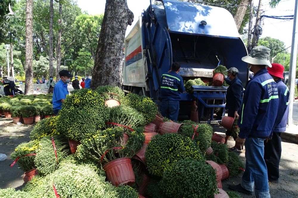 Xe ép rác công ty công viên cây xanh TP HCM tiêu hủy 500 chậu hoa ế sau khi gia đình anh Thiện đồng ý, trưa 31/1. Ảnh: Hà An