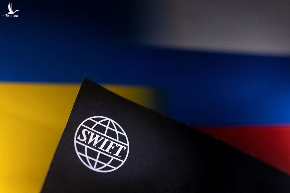 Logo SWIFT đặt trên nền cờ Nga vfa Ukraine. Ảnh: Reuters
