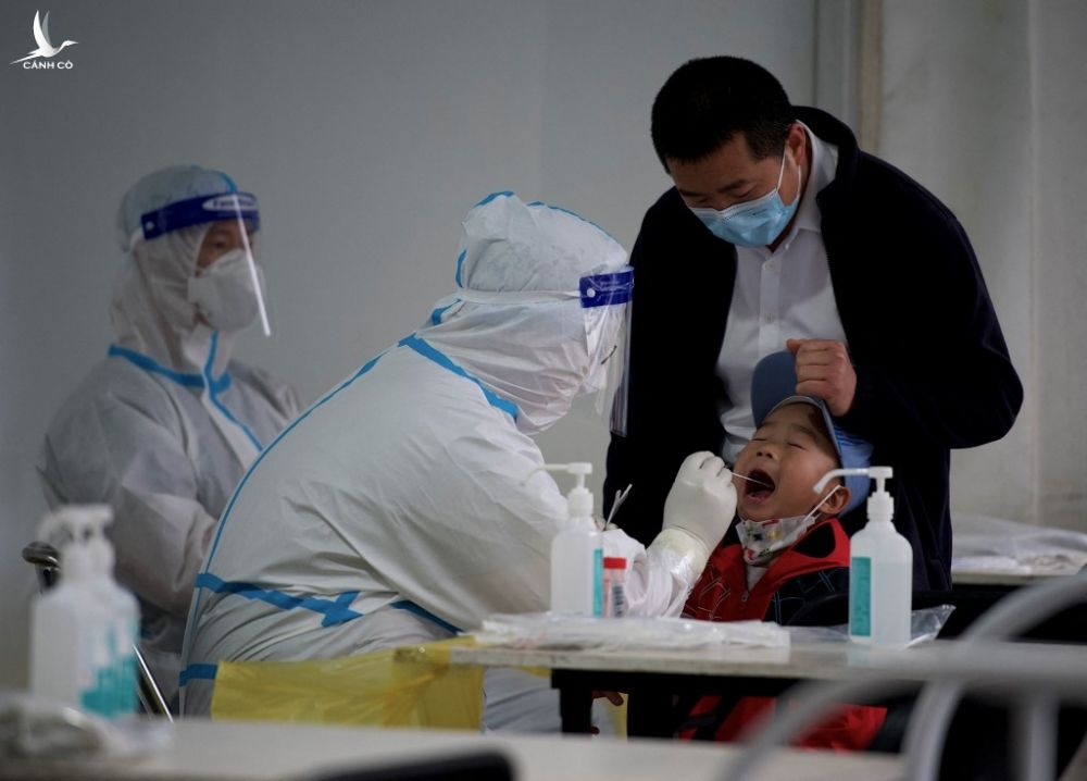 Nhân viên y tế lấy mẫu xét nghiệm Covid-19 cho bé trai ở Bắc Kinh, Trung Quốc hôm 25/4. Ảnh: AFP.