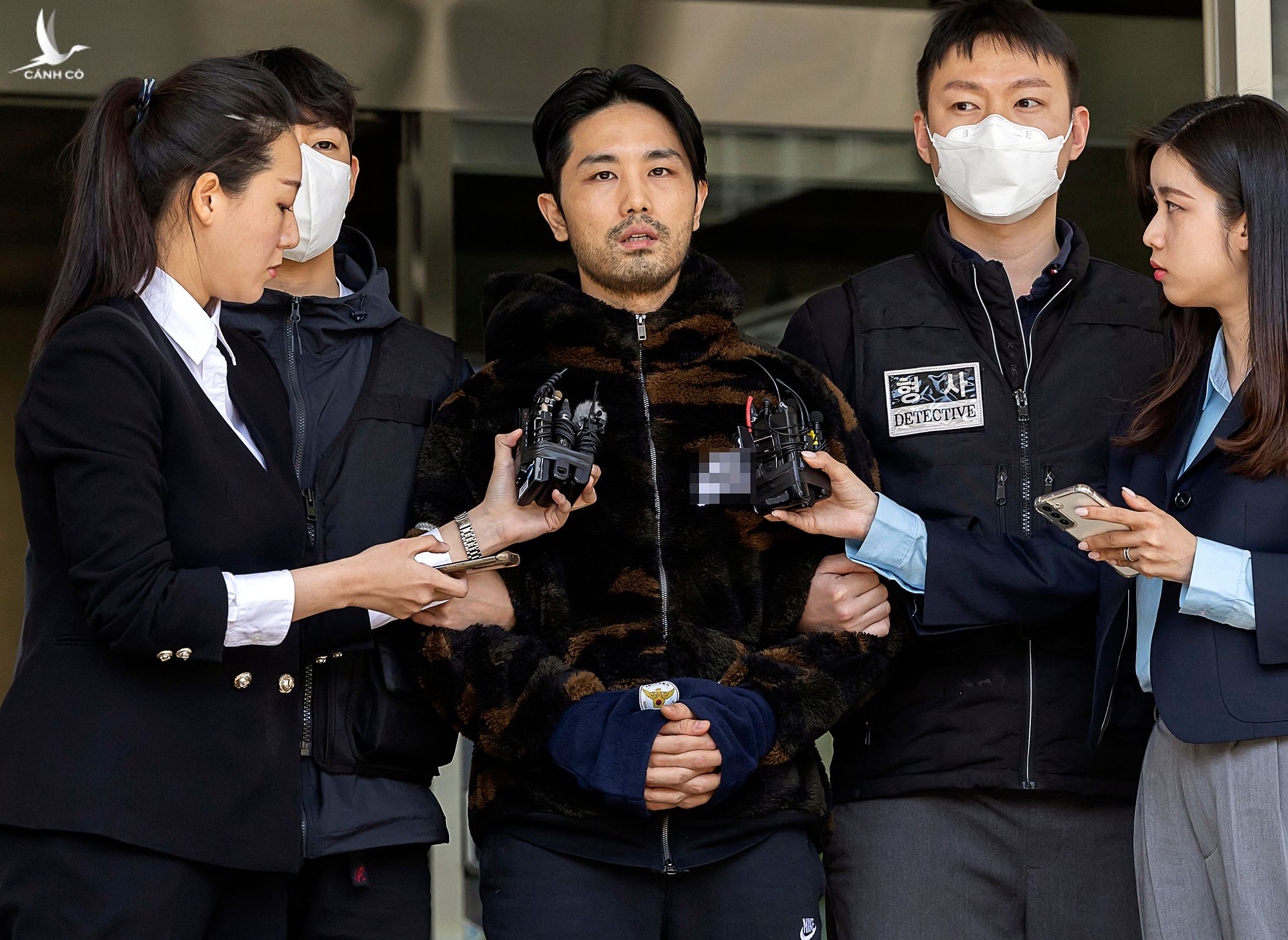 Lee Kyung-woo (giữa), bị áp giải từ đồn cảnh sát tới cơ quan công tố ở Seoul, ngày 9/4.