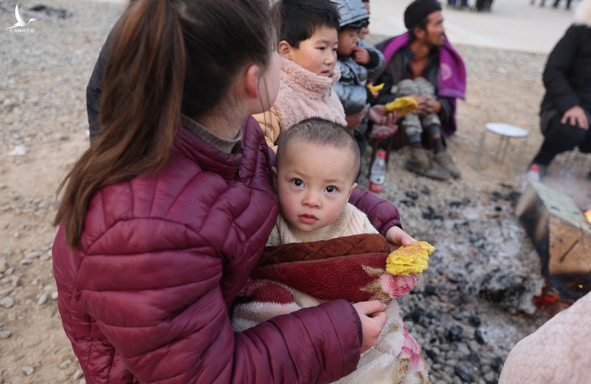 Người dân đốt củi sưởi ấm ngoài trời sau khi xảy ra vụ động đất ở tỉnh Cam Túc, Trung Quốc, hôm 18/12. 