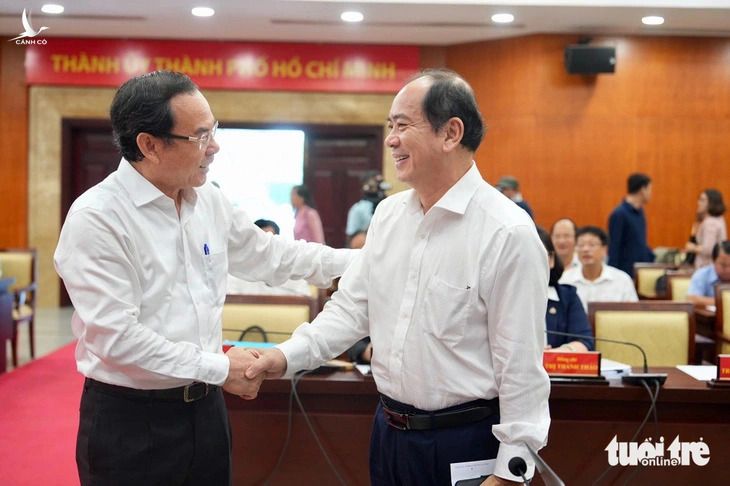 Bí thư Thành ủy Nguyễn Văn Nên (trái) trao đổi với các đại biểu trước hội nghị.
