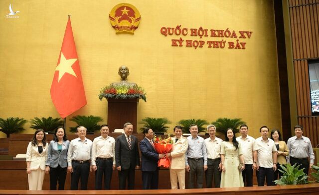 Tân Bộ trưởng Công an Lương Tam Quang nhận hoa chúc mừng từ Thủ tướng Phạm Minh Chính.