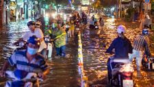 Người dân TP.HCM bì bõm lội nước về nhà trong mưa lớn
