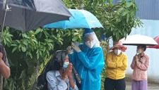 Nữ tình nguyện viên ở TP.HCM cầm ô che cho cụ già dưới trời mưa lớn